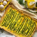 Slab quiche is a show-stopping way to make eggs for a crowd! These sheet-pan eggs have a rich, flakey crust speckled with sesame seeds and a velvety filling of eggs, cheeses,spring asparagus and peas. 