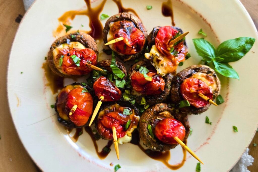 Air fryer Caprese Stuffed Mushrooms are a low carb, 31-calorie, easy appetizer made with mozzarella, tomato, basil, and balsamic glaze in just 15 minutes.